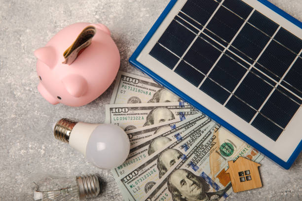 A flat lay composition featuring solar panels, an LED lamp, and a piggy bank, symbolizing the cost savings and sustainability of Solar BC's renewable energy solutions.